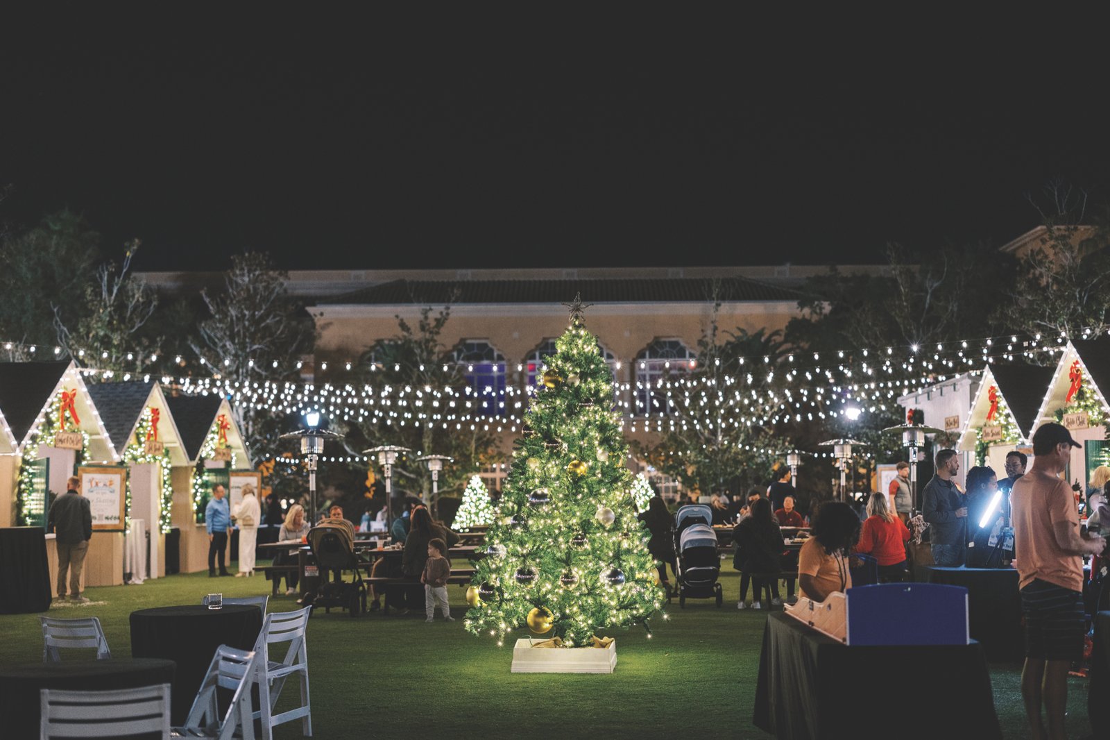 Grande Lakes Orlando Christmas Market Christmas Market cottages and a lit Christmas tree at night at Grande Lakes Orlando