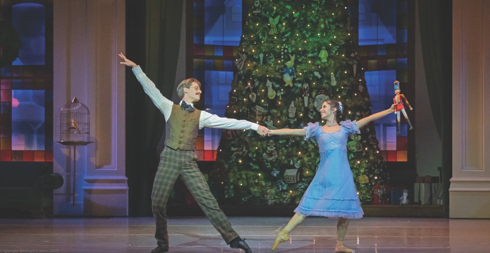 The Nutcracker Dancers performing The Nutcracker in front of a lit Christmas tree